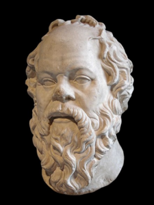 A white statue of a bearded person
Description automatically generated