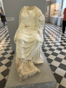 A statue of a person sitting in a room
AI-generated content may be incorrect.